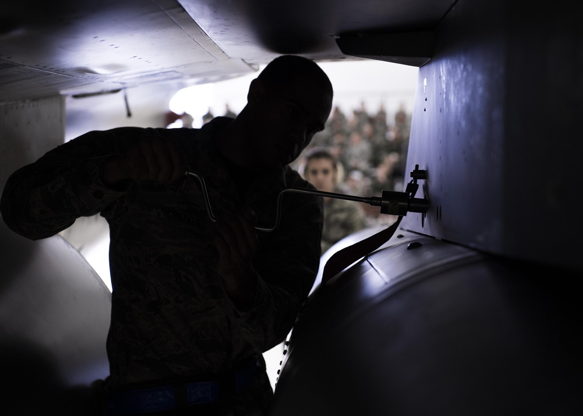 A1C Jonathan, 54th Fighter Group load crew member, secures an inert munition onto an F-16 Fighting Falcon during a quarterly load crew competition at Holloman Air Force Base, N.M., Jan. 20, 2016. The weapons load crews for German Air Force Tornado, F-16 Fighting Falcon and MQ-9 Reaper competed against each other to load weapons the most efficiently and with the least amount of procedural errors. Points for the competition are awarded based on weapons loading, tool kit inspection and uniform inspection categories. (U.S. Air Force photo by Senior Airman Chase Cannon/ Released)