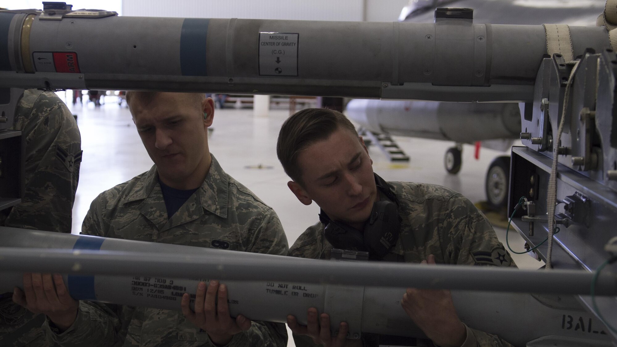 Members of the 54th Fighter Group load crew prepare to load an inert munition onto an F-16 Fighting Falcon during a quarterly load crew competition at Holloman Air Force Base, N.M., Jan. 20, 2016. The weapons load crews for German Air Force Tornado, F-16 Fighting Falcon and MQ-9 Reaper competed against each other to load weapons the most efficiently and with the least amount of procedural errors. Points for the competition are awarded based on weapons loading, tool kit inspection and uniform inspection categories. (U.S. Air Force photo by Senior Airman Chase Cannon/ Released)