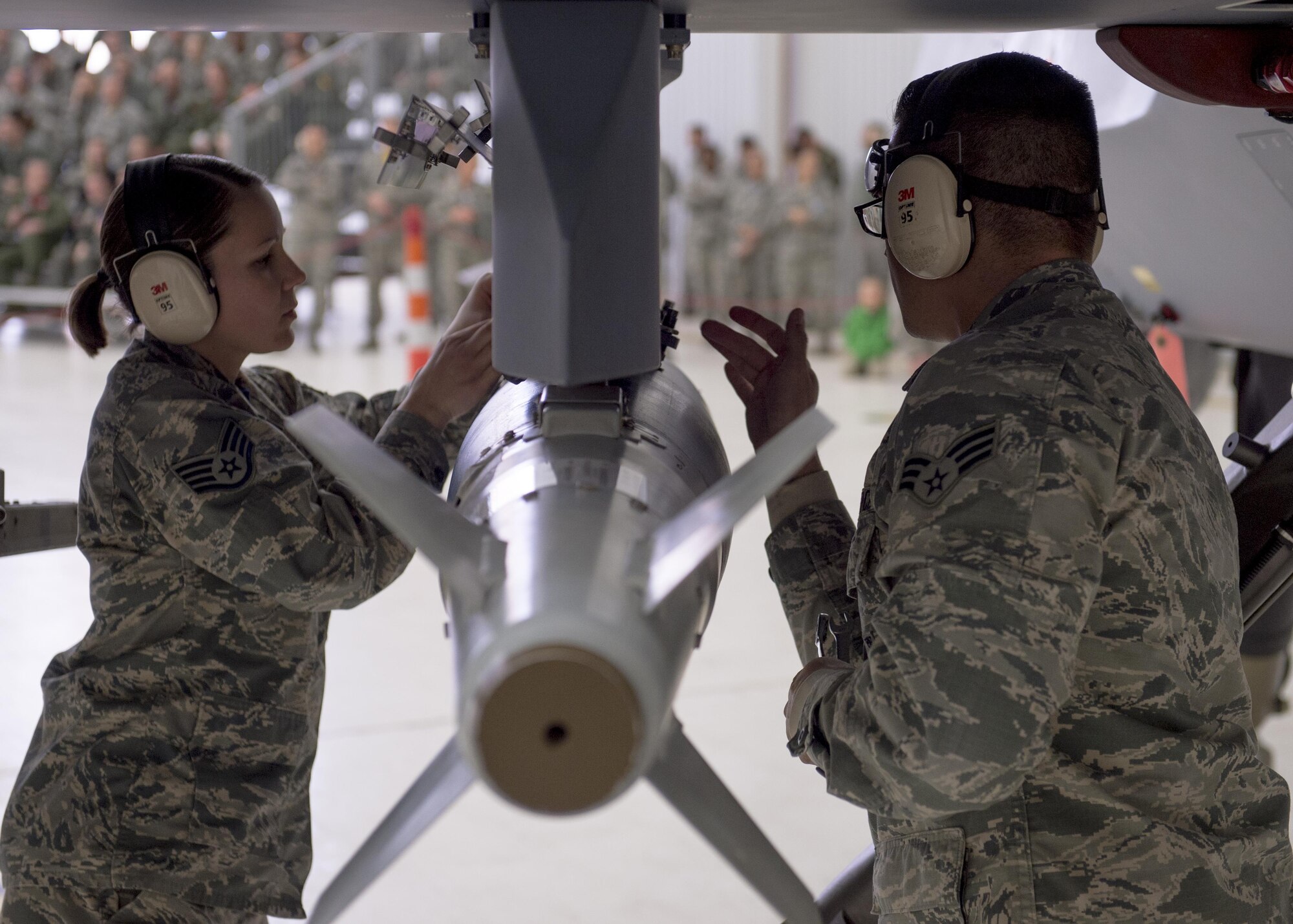 Members of the 49th Wing Maintenance Group inspect an inert munition before loading it onto an MQ-9 Reaper during a quarterly load crew competition at Holloman Air Force Base, N.M., Jan. 20, 2016. The weapons load crews for German Air Force Tornado, F-16 Fighting Falcon and MQ-9 Reaper competed against each other to load weapons the most efficiently and with the least amount of procedural errors. Points for the competition are awarded based on weapons loading, tool kit inspection and uniform inspection categories. (U.S. Air Force photo by Senior Airman Chase Cannon/ Released)