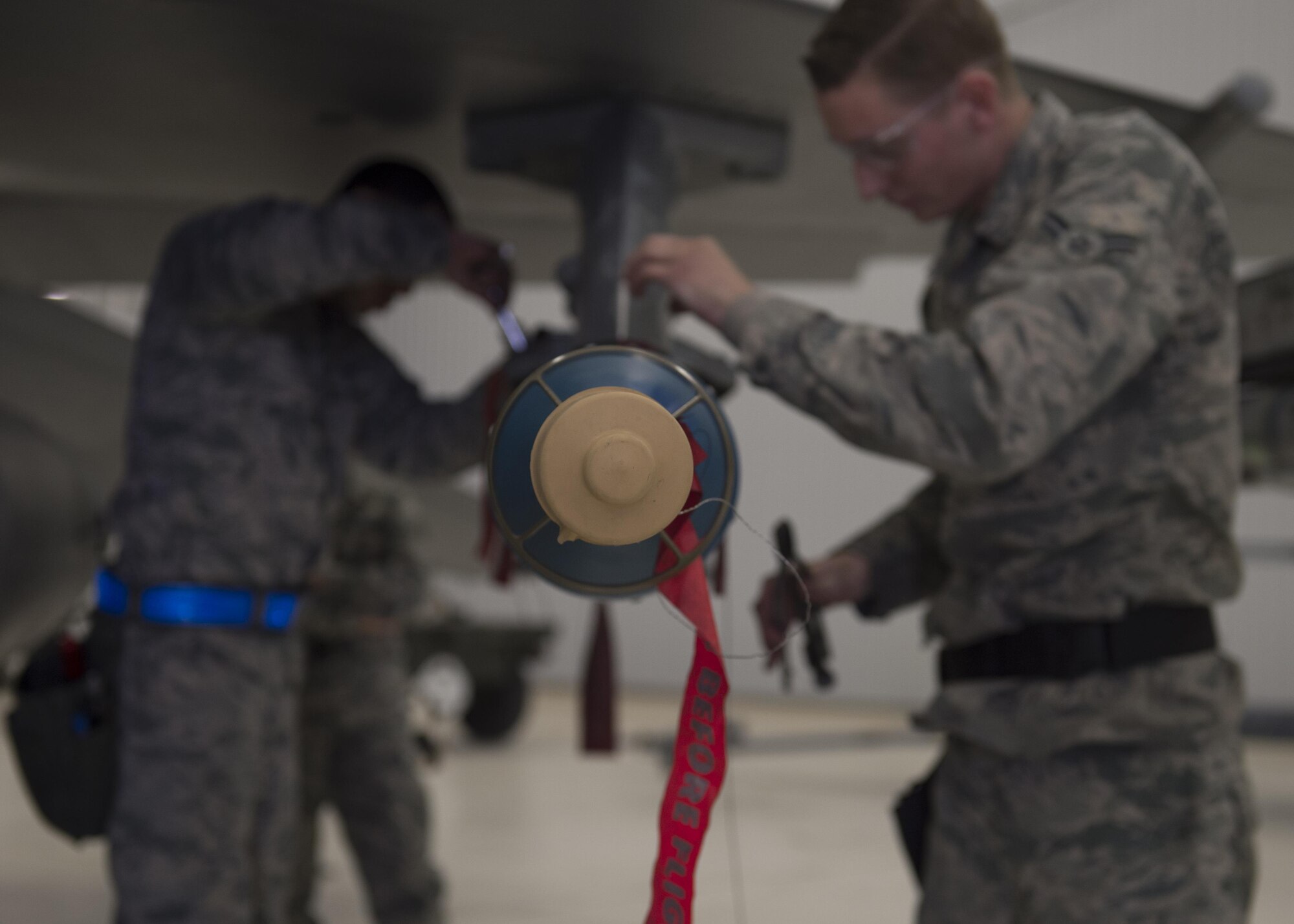 Members of the 54th Fighter Group load crew secure an inert munition onto an F-16 Fighting Falcon during a quarterly load crew competition at Holloman Air Force Base, N.M., Jan. 20, 2016. The weapons load crews for German Air Force Tornado, F-16 Fighting Falcon and MQ-9 Reaper competed against each other to load weapons the most efficiently and with the least amount of procedural errors. Points for the competition are awarded based on weapons loading, tool kit inspection and uniform inspection categories. (U.S. Air Force photo by Senior Airman Chase Cannon/ Released)