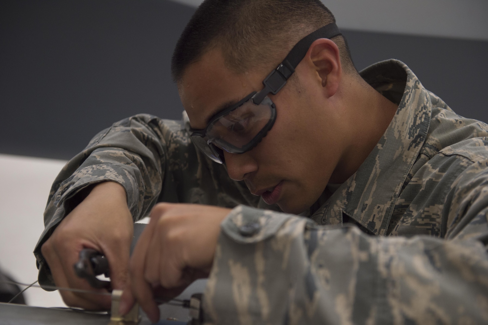 Airman 1st Class Daniel, an MQ-9 Reaper weapons load crew member, prepares an inert munition before loading it onto an MQ-9 Reaper during a quarterly load crew competition at Holloman Air Force Base, N.M., Jan. 20, 2016. The weapons load crews for German Air Force Tornado, F-16 Fighting Falcon and MQ-9 Reaper competed against each other to load weapons the most efficiently and with the least amount of procedural errors. Points for the competition are awarded based on weapons loading, tool kit inspection and uniform inspection categories. (U.S. Air Force photo by Senior Airman Chase Cannon/ Released)
