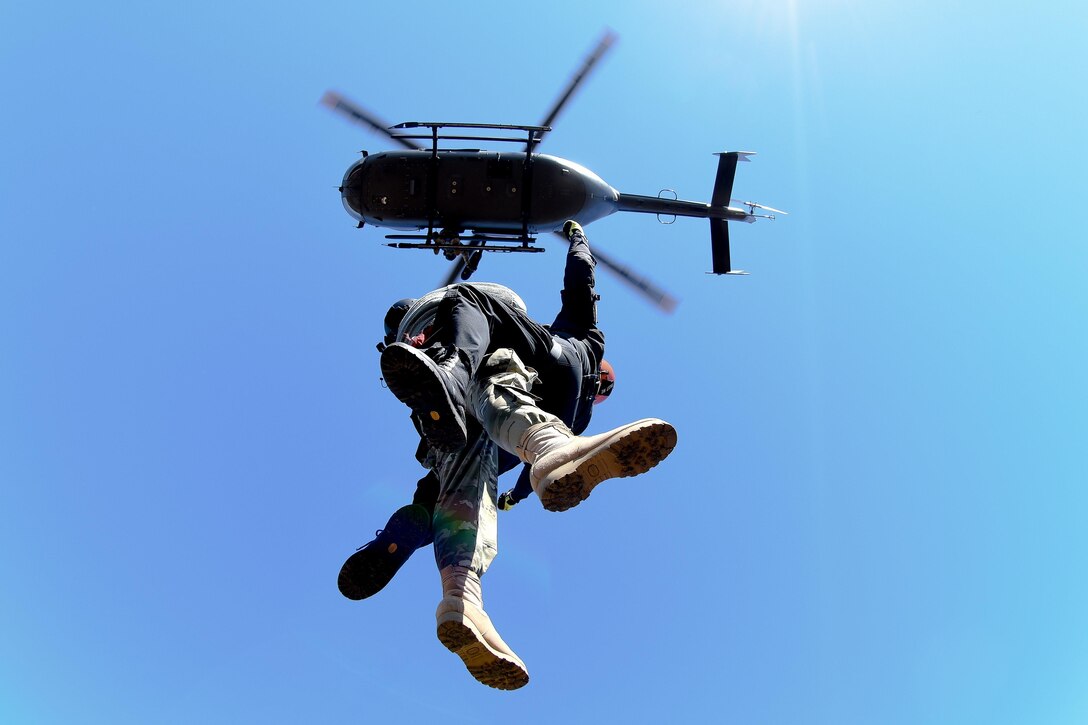 An Army National Guard crew chief assists an emergency first responder being hoisted up to a LUH-72A Lakota helicopter during the first phases of Patriot South Exercise 2017, at the Gulfport and Port Bienville Industrial Complex, Mississippi, Jan. 29, 2017. Army National Guard photo by Staff Sgt. Roberto Di Giovine