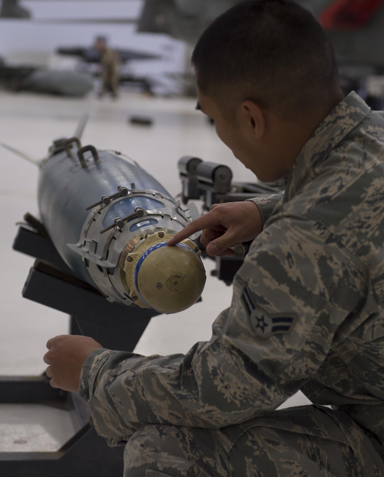 Airman 1st Class Daniel, an MQ-9 Reaper weapons load crew member, inspects an inert munition before loading it onto an MQ-9 during a quarterly load crew competition at Holloman Air Force Base, N.M., Jan. 20, 2016. The weapons load crews for the German Air Force Tornado, F-16 Fighting Falcon and MQ-9 Reaper competed against each other to load weapons the most efficiently and with the least amount of procedural errors. Points for the competition are awarded based on weapons loading, tool kit inspection and uniform inspection categories. (U.S. Air Force photo by Senior Airman Chase Cannon/ Released)