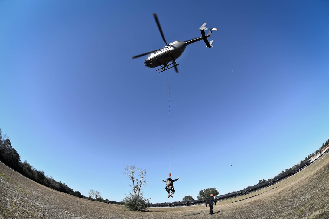 An Army National Guard crew chief and an emergency first responder are lowered from a LUH-72A Lakota helicopter during the first phases of Patriot South Exercise 2017, at the Gulfport and Port Bienville Industrial Complex, Mississippi, Jan. 29, 2017. Army National Guard photo by Staff Sgt. Roberto Di Giovine