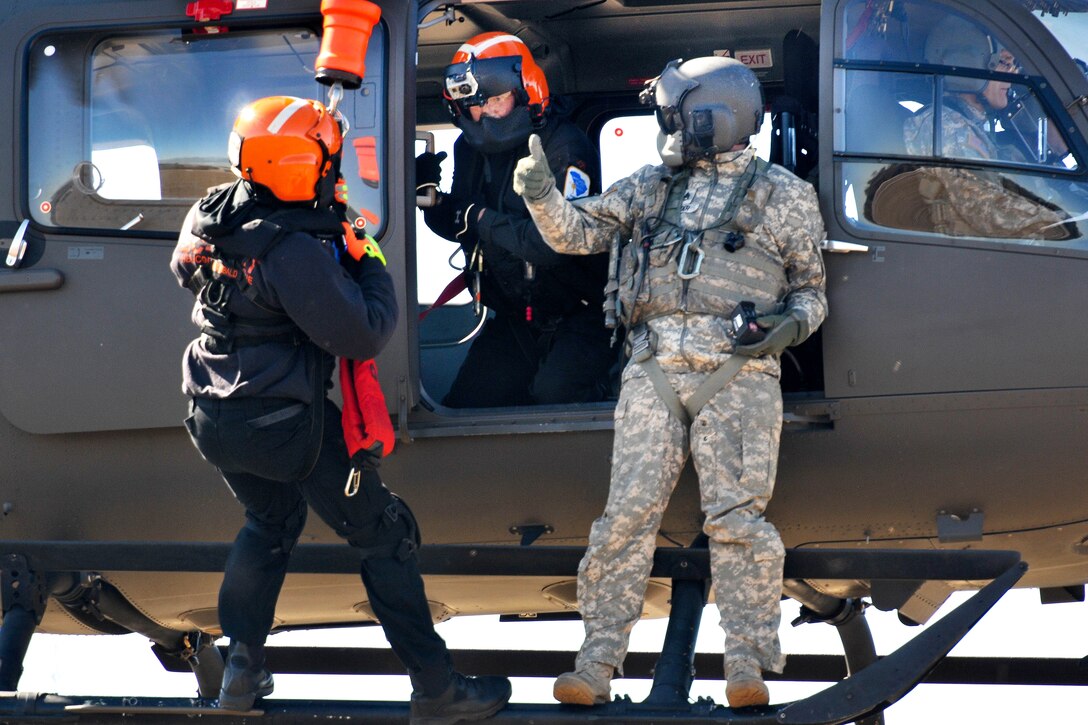 An Army National Guard crew chief gives the thumbs up that it’s all clear to lower an emergency first responder from a LUH-72A Lakota helicopter during the first phases of Patriot South Exercise 2017, at the Gulfport and Port Bienville Industrial Complex, Mississippi, Jan. 29, 2017. Army National Guard photo by Staff Sgt. Roberto Di Giovine