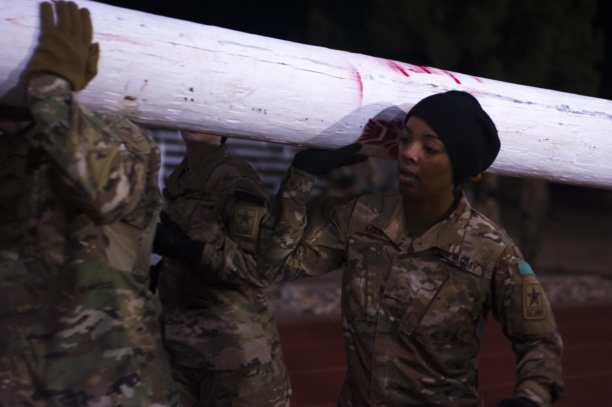 A soldier from the 344th Military Intelligence Battalion carries a log with their team during the Spartan Race at the Mathis Fitness Center football field on Goodfellow Air Force Base, Texas, February 3, 2017. The Spartan Race is a circuit, containing a 1.8 mile ruck march, a log carry around the track for 1 mile, body carries, 100 pullups and a Humvee drag. (U.S. Air Force photo by Senior Airman Scott Jackson/released)