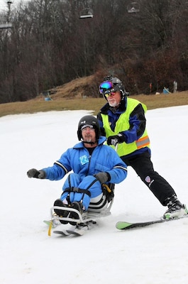 Marcus Brumbaugh, an electrical mechanic from the Nashville District skies downhill with military veteran Dean Tisdale an adaptive skier during the 36th Disabled Sports USA Adaptive Learn to Ski event clinic held Jan. 19, 2017 at the Beech Mountain Resort in Beech Mountain, N.C.   