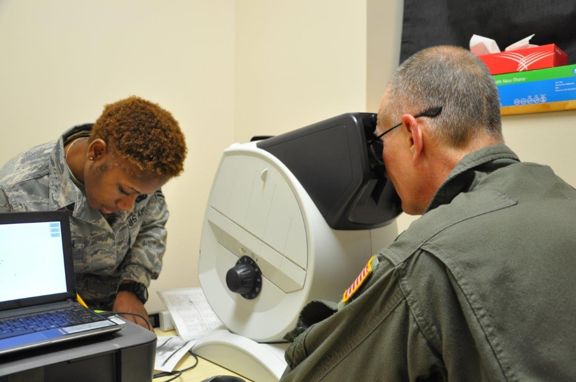 Staff Sgt. Shaniqua Anderson performs a depth perception test on a member on flying status during a Periodic Health Assessment. Col. Roger Hasselbrock relays back to Sgt. Anderson what he sees in the optic vision tester. The Base and Operational Medicine Clinic performs PHA’s on all military personnel on flying status. (U.S. Air Force photo/Myra Saxon)