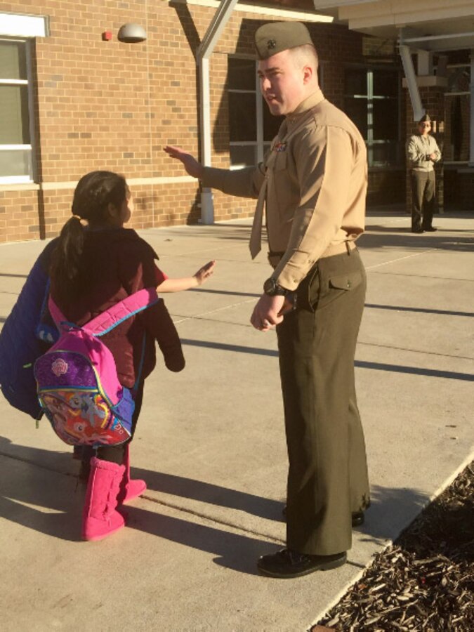 Capt Magyar welcoming students with a high five at Triangle Elementary School.