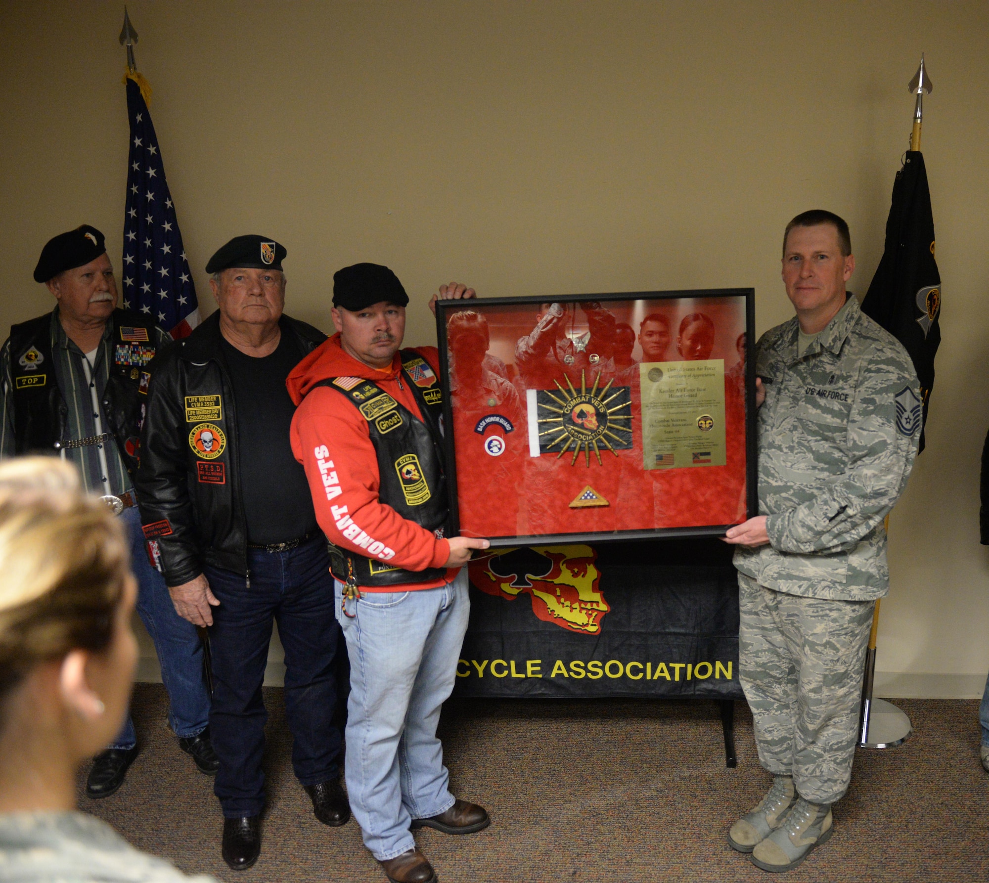Members of the Combat Veteran Motorcycle Association present Master Sgt. Larry Davidson, Keesler Air Force Base Honor Guard superintendent, a shadow box in the Locker House Jan. 26, 2017, on Keesler AFB, Miss. The group presented the shadow box to the Keesler AFB Honor Guard for their roll in five Congressional Medal of Honor ceremonies and numerous funerals held at the Biloxi National Cemetery during the last six years. (U.S. Air Force photo by Airman 1st Class Travis Beihl)