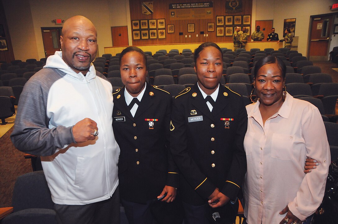 Olympic gold medalist and former champion boxer Ray “Merciless” Mercer poses with twin daughters Ramia and Raina, and wife Krystal, after the twins’ graduation from the Automated Logistical Course Friday at Mullins Auditorium. Ramia and Raina Mercer are U.S. Army Reservists who plan on enrolling in college and becoming pediatricians. Mercer was one of three boxing Soldiers who reigned victorious in the 1988 Seoul Olympics.  He also had a successful career as a professional, winning World Boxing Organization and North American Boxing Federation titles.