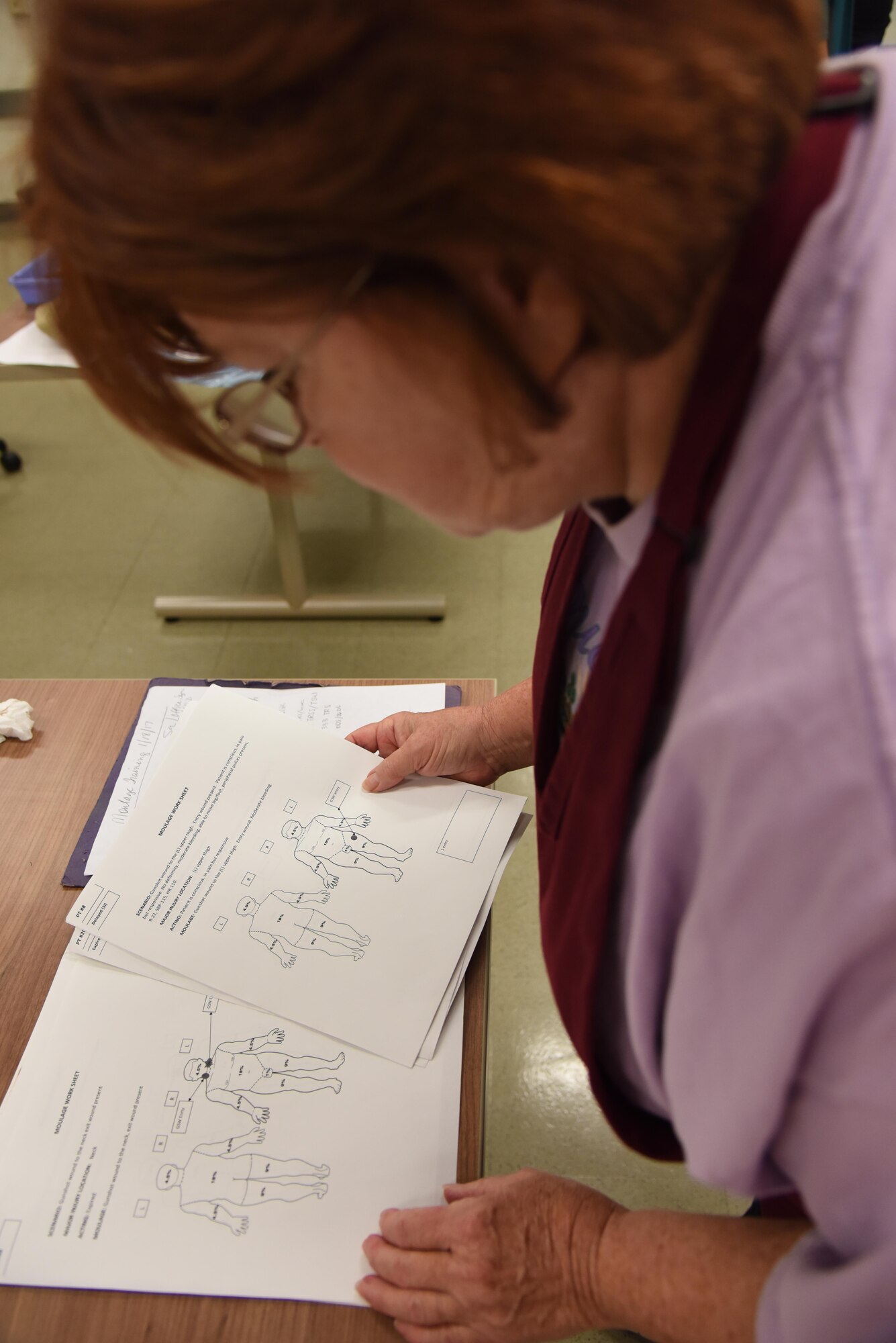 Regina Parker, 81st Medical Operations Squadron mental health secretary and moulage co-team lead, sorts through work sheets during a moulage training session at Allee Hall Jan. 18, 2017, on Keesler Air Force Base, Miss. The session was held to teach volunteers how to apply moulage on exercise “casualties” to provide emergency responders with a more realistic training experience. (U.S. Air Force photo by Kemberly Groue)