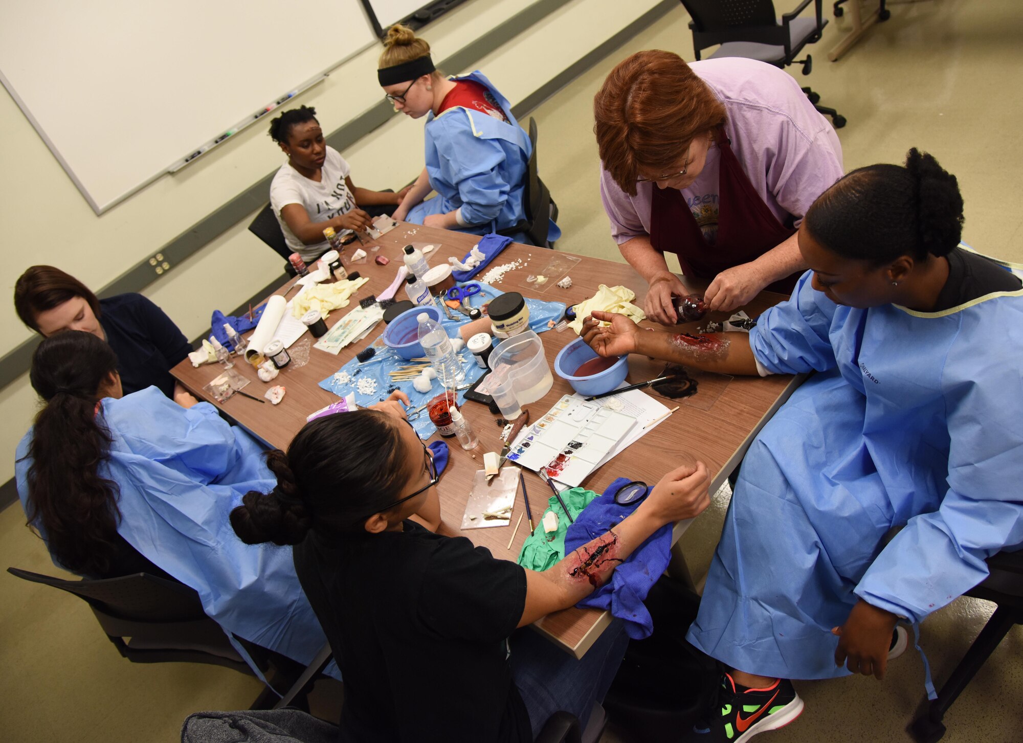 Volunteers learn how to apply moulage during a training session at Allee Hall Jan. 18, 2017, on Keesler Air Force Base, Miss. The session was held to teach volunteers how to apply moulage on exercise “casualties” to provide emergency responders with a more realistic training experience. (U.S. Air Force photo by Kemberly Groue)