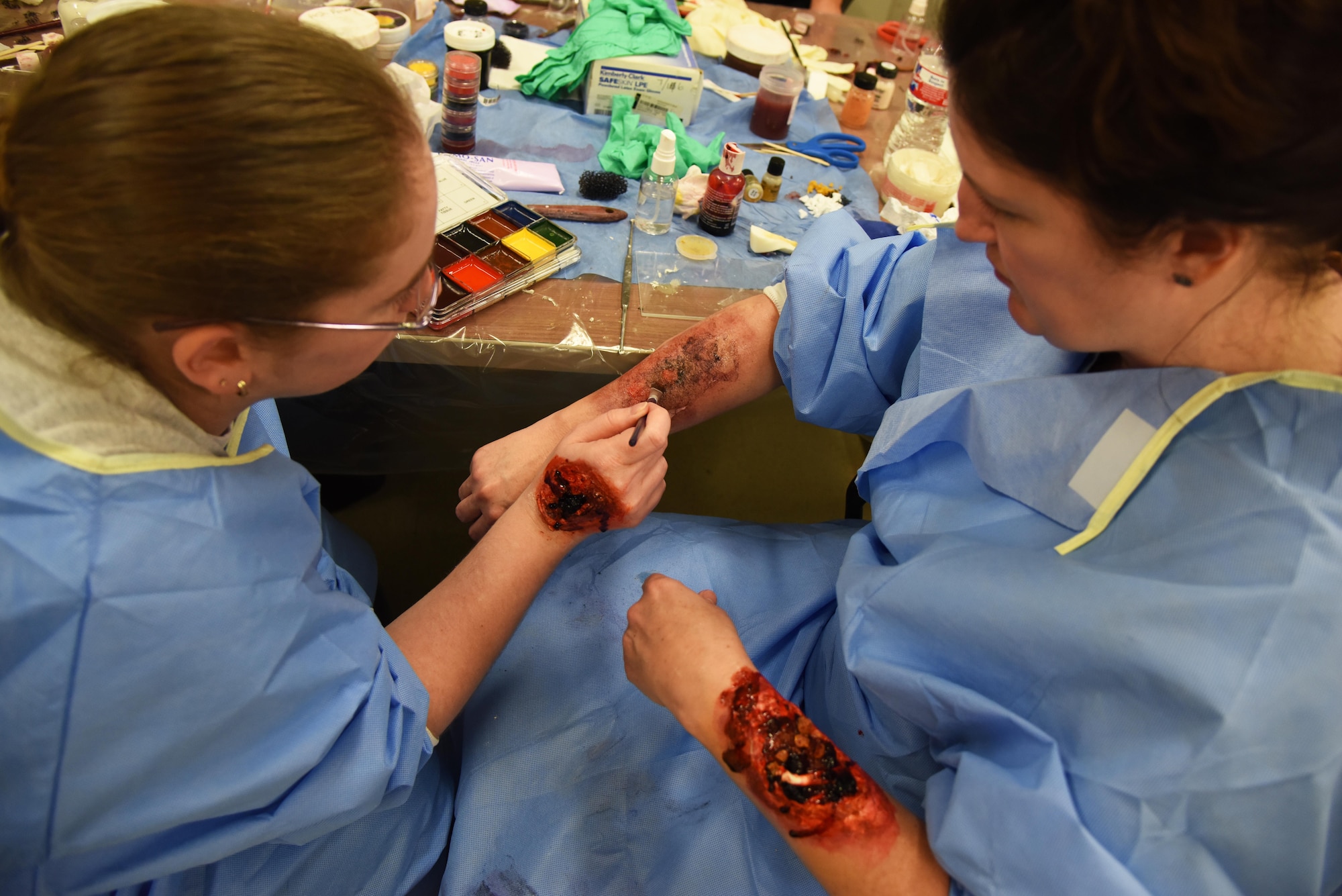 Tiffany Entrekin, Merit Health Biloxi registered nurse, applies moulage to Deadra Baldwin, Merit Health Biloxi registered nurse, during a training session at Allee Hall Jan. 18, 2017, on Keesler Air Force Base, Miss. The session was held to teach volunteers how to apply moulage on exercise “casualties” to provide emergency responders with a more realistic training experience. (U.S. Air Force photo by Kemberly Groue)