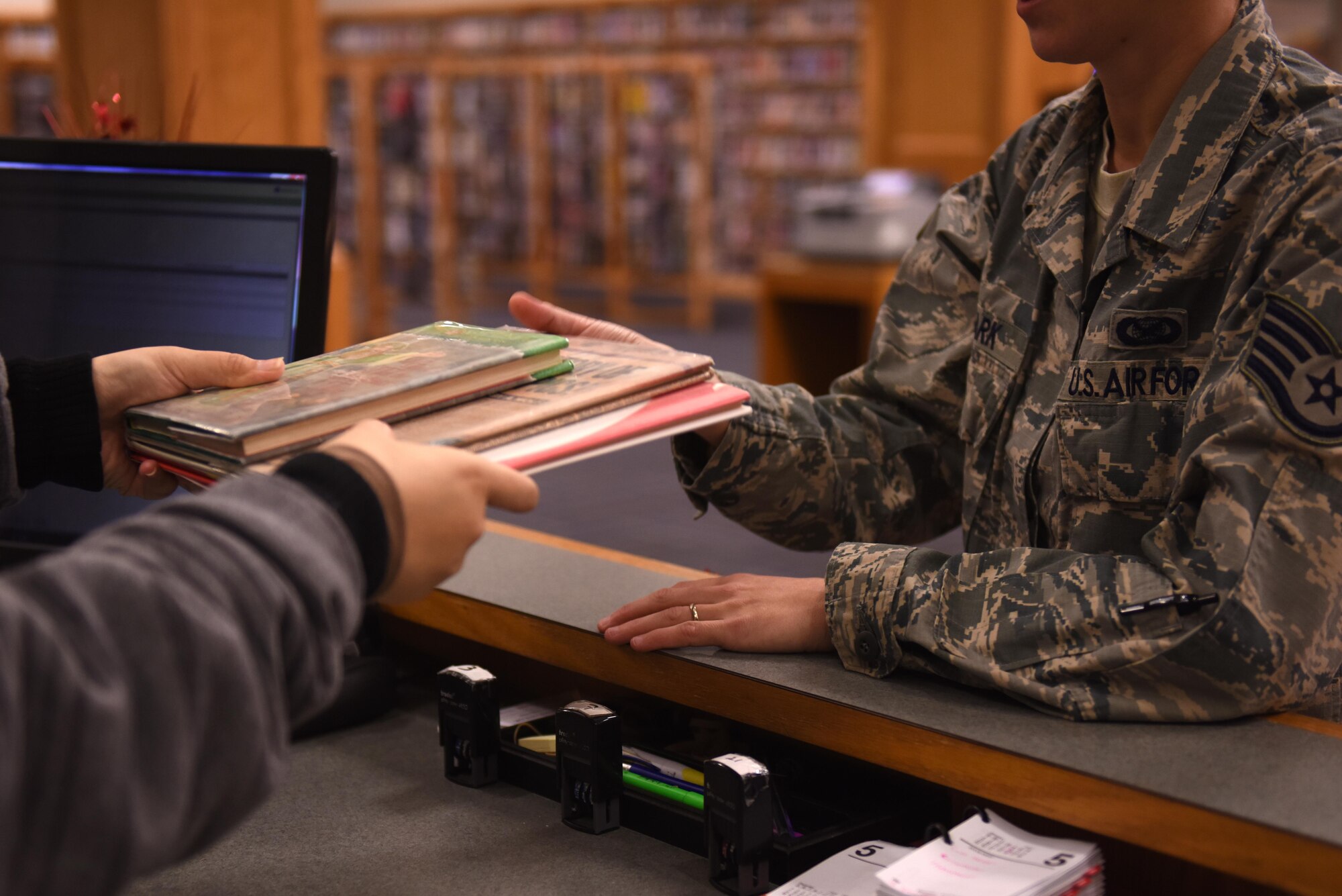 A military member checks out a book at the Little Rock Air Force Base Library Jan. 18, 2017. The LRAFB library, located in the Walters Community Center, has a growing collection of more than 20,000 books, 5,000 DVD’s, 100 music CD’s, 1,000 audio books, several different games for a variety of gaming systems, and 80 periodical and newspaper subscriptions. (U.S. Air Force photo by Airman 1st Class Codie Collins)