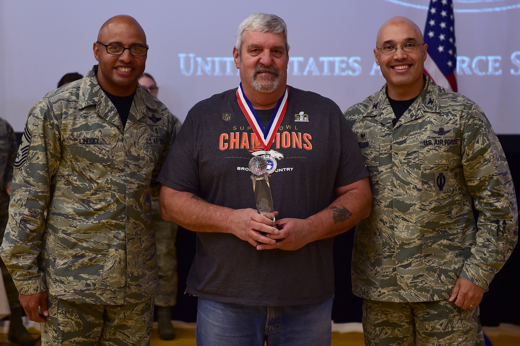 Ernie Gordon, 460th Mission Support Group, center, receives the Civilian Category I, Non-supervisory of the Year Award, from Col. David Miller Jr., 460th Space Wing commander, and Chief Master Sgt. Rod Lindsey, 460th SW command chief, Feb. 3, 2017, at the annual awards on Buckley Air Force Base, Colo. The annual awards is a ceremony that recognizes the significant achievements, dedication and skill of the military and civilian members of the 460th SW. (U.S. Air Force photo by Airman Jacob Deatherage/Released)
