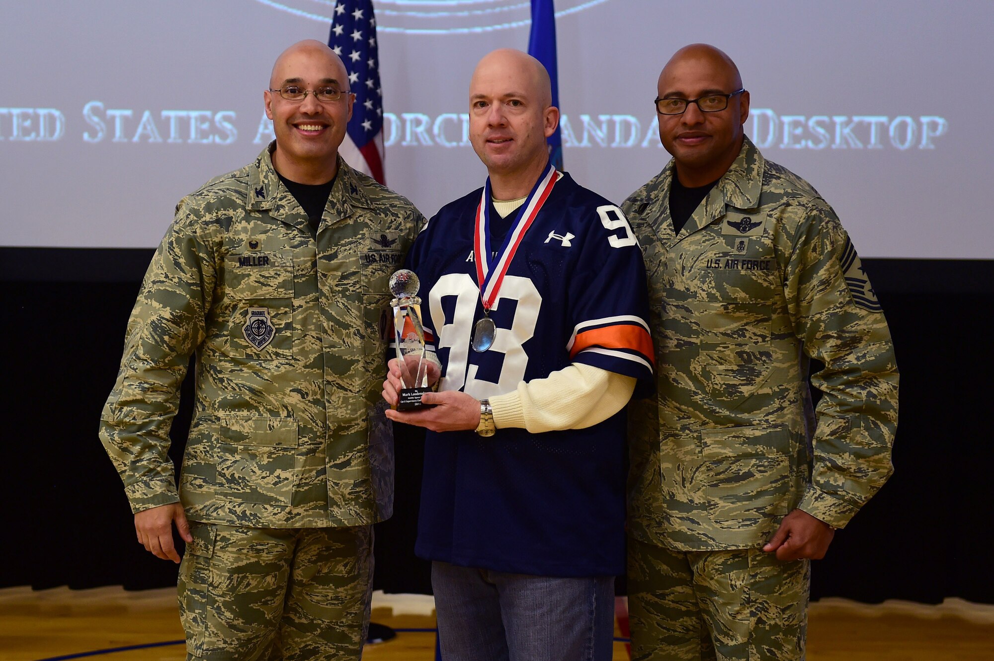 Mark Laudenslager, 460th Mission Support Group, center, receives the Civilian Category II Supervisory of the Year Award, from Col. David Miller Jr., 460th Space Wing commander, and Chief Master Sgt. Rod Lindsey, 460th SW command chief, Feb. 3, 2017, at the annual awards on Buckley Air Force Base, Colo. The annual awards is a ceremony that recognizes the significant achievements, dedication and skill of the military and civilian members of the 460th SW. (U.S. Air Force photo by Airman Jacob Deatherage/Released)