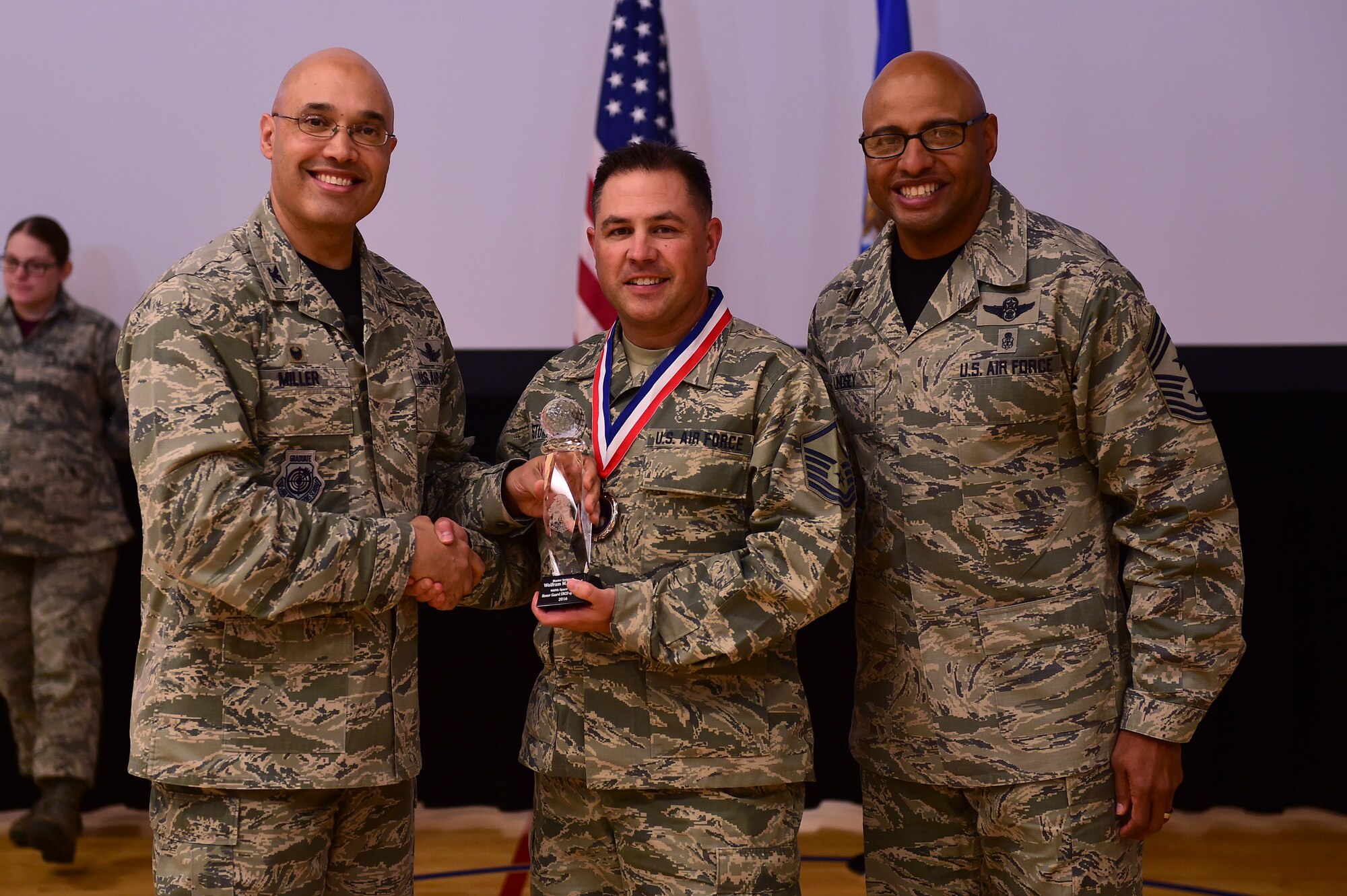 Master Sgt. Wolfram Stumpf, Mile High Honor Guard NCO, center, receives the Honor Guard NCO of the Year Award, from Col. David Miller Jr., 460th Space Wing commander, and Chief Master Sgt. Rod Lindsey, 460th SW command chief, Feb. 3, 2017, at the annual awards on Buckley Air Force Base, Colo. The annual awards is a ceremony that recognizes the significant achievements, dedication and skill of the military and civilian members of the 460th SW. (U.S. Air Force photo by Airman Jacob Deatherage/Released)