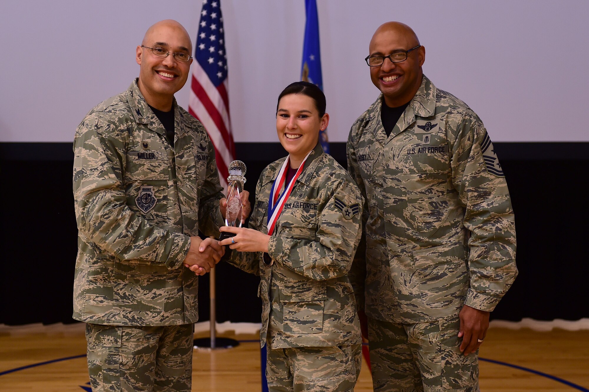 Senior Airman Sarah Gilbert, 460th Medical Group, receives the Airman of the Year Award, from Col. David Miller Jr., 460th Space Wing commander, and Chief Master Sgt. Rod Lindsey, 460th SW command chief, Feb. 3, 2017, at the annual awards on Buckley Air Force Base, Colo. The annual awards is a ceremony that recognizes the significant achievements, dedication and skill of the military and civilian members of the 460th SW. (U.S. Air Force photo by Airman Jacob Deatherage/Released)