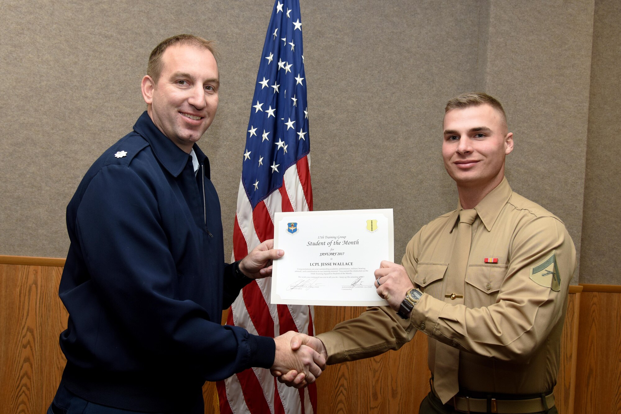 U.S. Air Force Lt. Col. Jason Kulchar, 315th Training Squadron director of operations, presents the 316th Training Squadron Student of the Month award for January 2017 to Lance Cpl. Jesse Wallace, 316th TRS student, in the Brandenburg Hall on Goodfellow Air Force Base, Texas, Feb. 3, 2017. (U.S. Air Force photo by Staff Sgt. Joshua Edwards/Released)