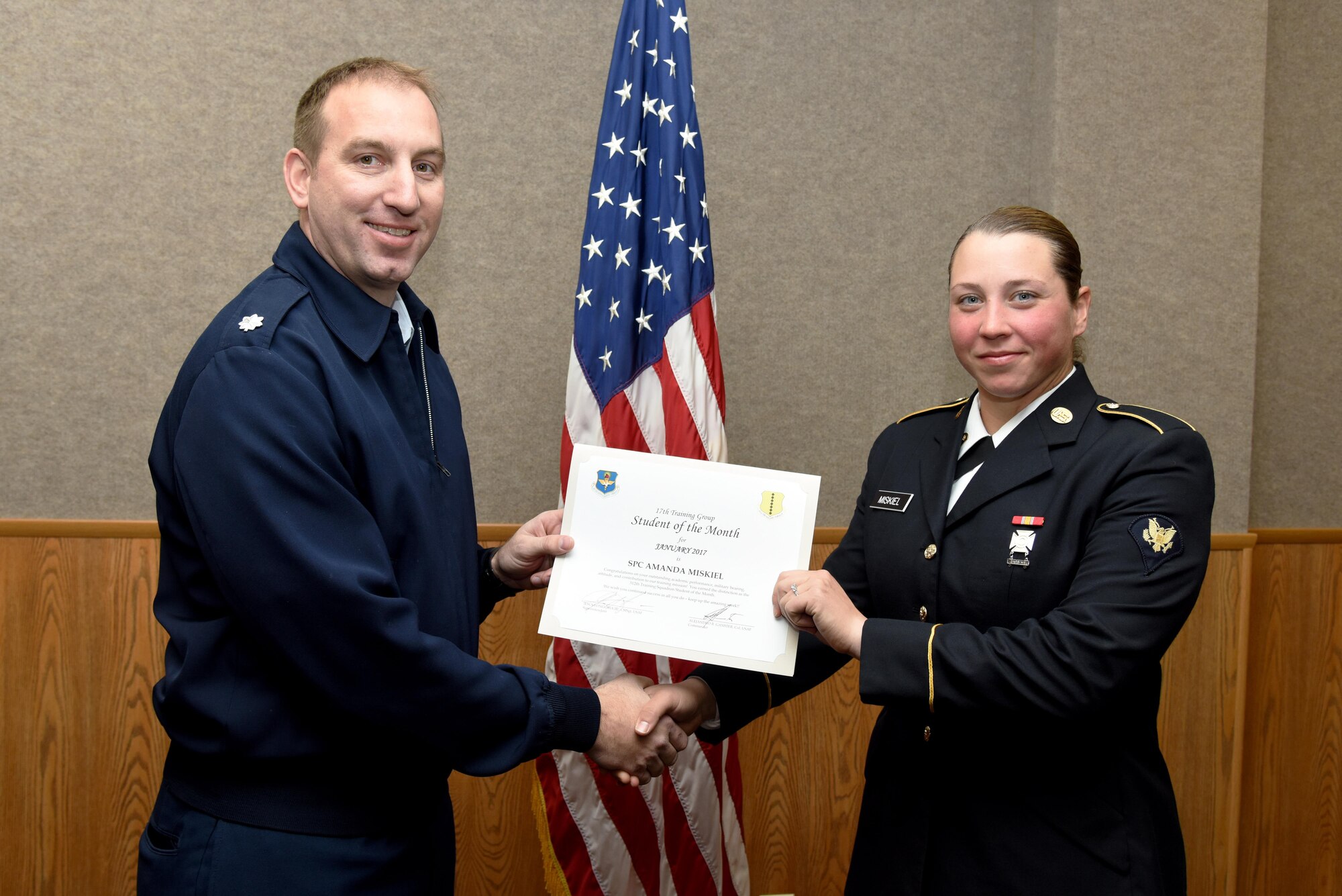 U.S. Air Force Lt. Col. Jason Kulchar, 315th Training Squadron director of operations, presents the 312th Training Squadron Student of the Month award for January 2017 to U.S. Army Spc. Amanda Miskiel, 312th TRS student, in the Brandenburg Hall on Goodfellow Air Force Base, Texas, Feb. 3, 2017. (U.S. Air Force photo by Staff Sgt. Joshua Edwards/Released)
