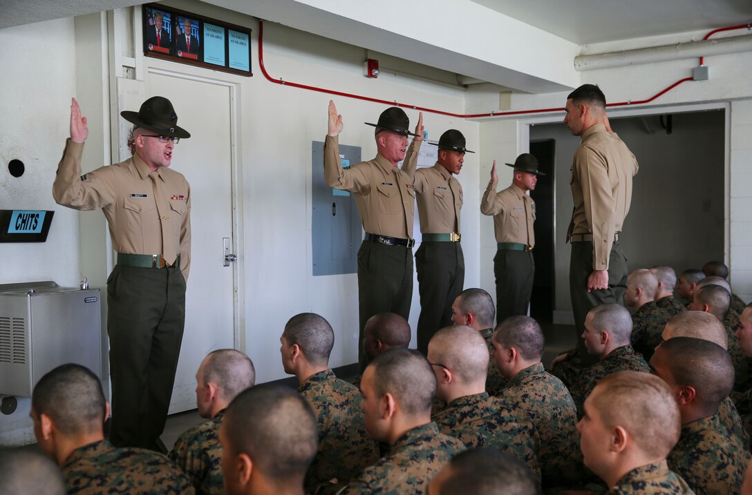 Drill instructors of Kilo Company, 3rd Recruit Training Battalion, recite the Drill Instructor Creed during pick up at Marine Corps Recruit Depot San Diego, Jan. 27. After spending the first week in-processing, recruits marched to their new squad bay where their drill instructors introduced themselves, recited the Drill Instructor Creed and began carrying out the mission of transforming civilians into United States Marines. Annually, more than 17,000 males recruited from the Western Recruiting Region are trained at MCRD San Diego. Kilo Company is scheduled to graduate April 21.