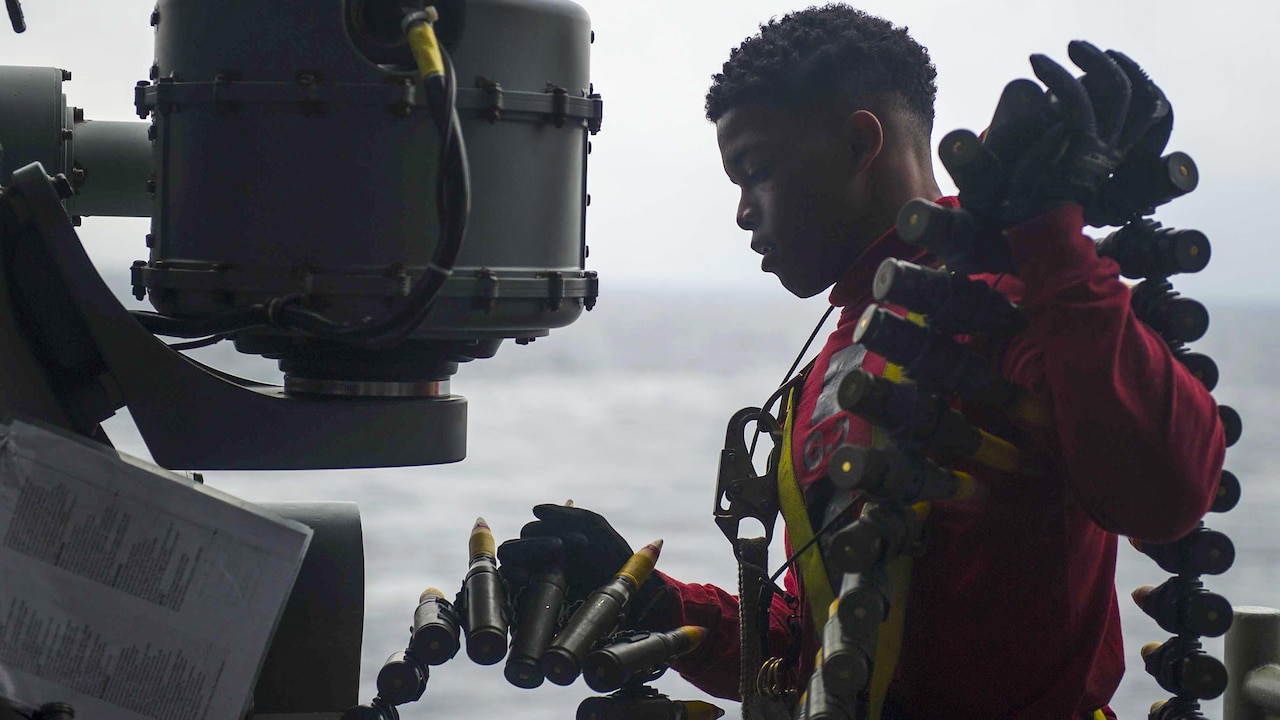 Navy Seaman Christian Wingate loads ammo into the Mark 38 machine gun for operational testing on the USS America in the Pacific Ocean, Feb. 2, 2017, as it prepares for deployment. Wingate is a gunner's mate. Navy photo by Petty Officer 3rd Class Arnesia McIntyre