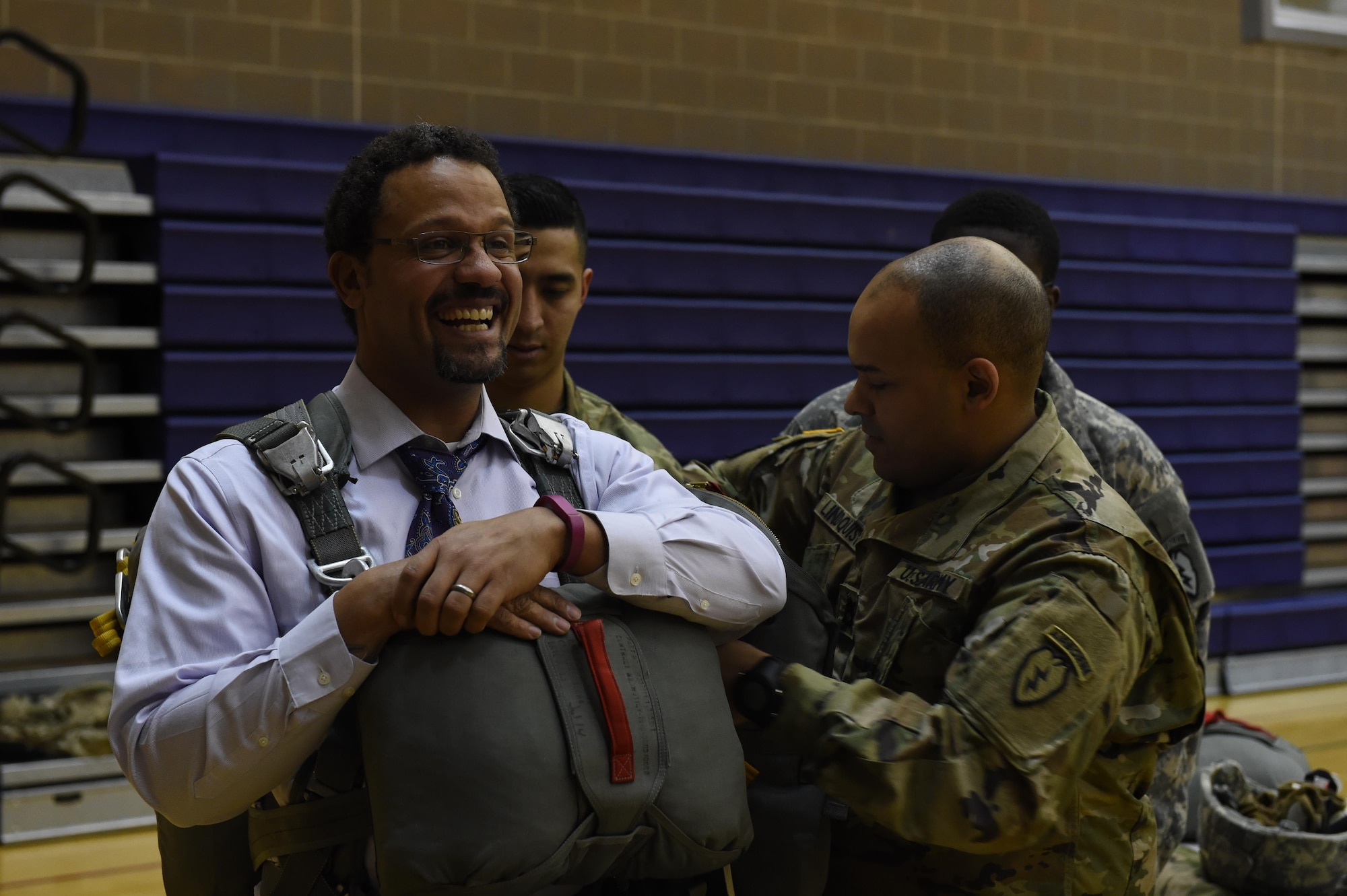 Sgt. 1st Class Kevin Lindquist, Headquarters and Headquarters Company, 4th Brigade Combat Team (Airborne), 25th Infantry Division, straps a T-11 parachute on Begich Middle School Principal Brian Singleton at Begich Middle School Feb. 2, 2017. The HHC, 4-25th IBCT Soldiers were one of many Science, Technology, Engineering, Art and Math presenters who interacted with about 300 students at the school's Career Fair. The fair is one of several annual events the unit's Soldiers support at the school as part of the Joint Base Elmendorf-Richardson School Partnership Program. 