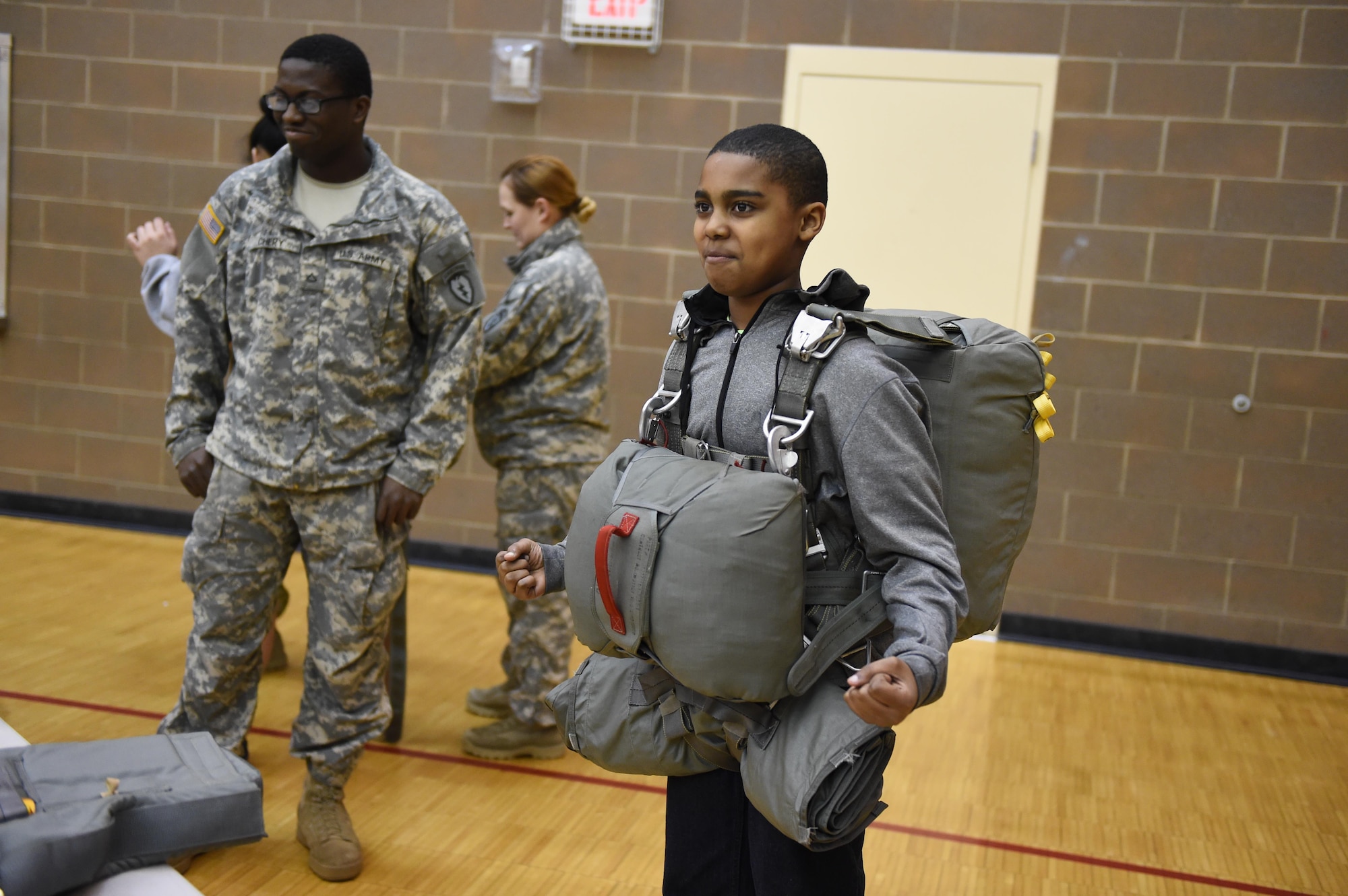 J’Lonie Wade, 12, poses for a photo after donning the T-11 parachute at Beigich Middle School, Feb. 2, 2017. Headquarters and Headquarters Company, 4th Brigade Combat Team (Airborne), 25th Infantry Division Soldiers were one of many Science, Technology, Engineering, Art and Math presenters who interacted with about 300 students at the school's Career Fair. The fair is one of several annual events the unit's Soldiers support at the school as part of the Joint Base Elmendorf-Richardson School Partnership Program. 