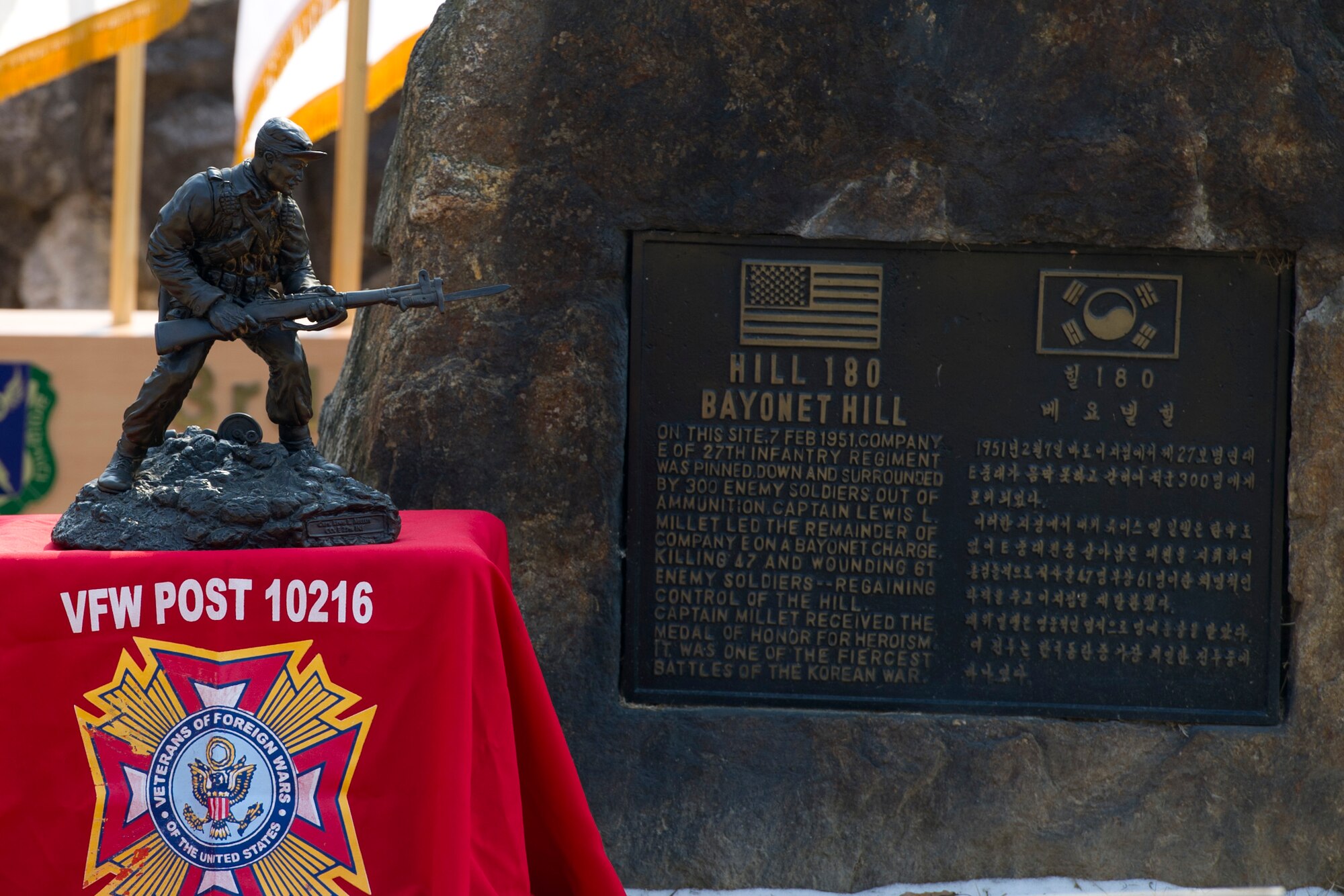 A statue of U.S. Army Capt. Lewis Millett sits in front of the Hill 180 Bayonet Hill memorial plaque during the 66th Anniversary of the Battle of Bayonet Hill Commemoration Ceremony on Osan Air Base, Republic of Korea, Feb. 3, 2017. On Feb. 7, 1951, Millett led Company E of the 27th Infantry Regiment, on a bayonet charge up Hill 180 -- killing 47 enemy soldiers and wounding 51. (U.S. Air Force photo by Staff Sgt. Jonathan Steffen)