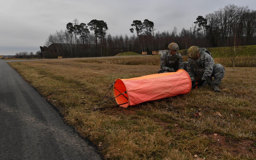 Tech. Sgt. George Broom, 435th Contingency Response Squadron contingency airfield manager, trains an Airman how to set up a simulated airfield during Exercise Austere Forge on Ramstein Air Base, Germany, Feb. 1, 2017. During the exercise, the Airmen planned what equipment would be used and who would be going, readied the equipment and personnel, processed through the 86th Logistic Readiness Squadron’s installation deployment readiness cell, and set up tents and equipment in a simulated deployed location. The 435 CRG participated in the exercise to practice their capability to deploy within 72 hours. (U.S. Air Force photo by Senior Airman Tryphena Mayhugh)