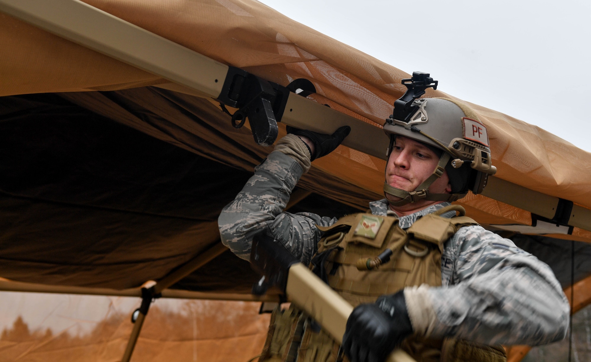 Airman 1st Class Ryan Daggett, 435th Contingency Response Squadron contingency response team member, builds a tent during Exercise Austere Forge on Ramstein Air Base, Germany, Feb. 1, 2017. Airmen in the 435th Contingency Response Group participated in the exercise to practice their capability to deploy within 72 hours. (U.S. Air Force photo by Senior Airman Tryphena Mayhugh)