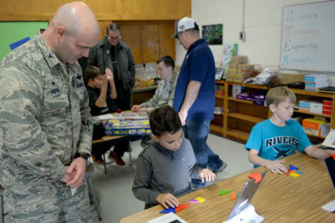 Air Force Col. Todd Hohn watches as students play with learning materials at Altus Air Force Base, Okla., Dec. 6, 2016. Air Force photo by Airman Jackson N. Haddon