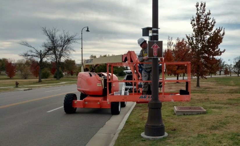 Air Force Tech. Sgt. Clayton Allen installs an alert route sign on a light pole, Nov. 17, 2016, at McConnell Air Force Base, Kan., Jan. 11, 2017. Allen and Air Force Master Sgt. Bartek Bachleda designed and built the signs, potentially saving the Air Force millions of dollars. Air Force photo by Master Sgt. Bartek Bachleda