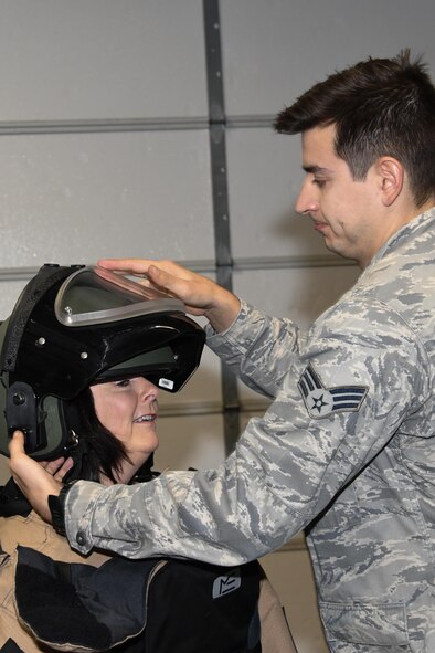 An Airman places the helmet of an Explosive Ordinance bomb suit on a member of the Young Presidents Organization Feb. 3, 2017, Barksdale Air Force Base, La.  The suit is used by 2nd Civil Engineer Squadron Explosive Ordinance Disposal flight members to safely handle unexploded ordinance.   Members of the YPO Louisiana Chapter visited Barksdale to get a better understanding of the various jobs and leadership challenges experienced by Airmen during day-to-day operations. (U.S. Air Force photo by Tech. Sgt. Ted Daigle/Released)