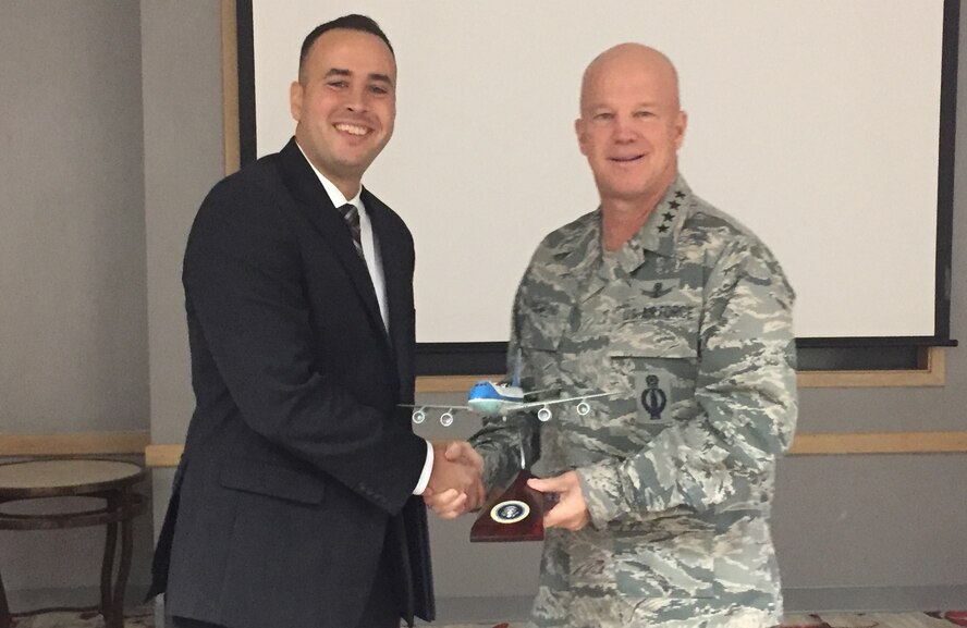 Gen. John W. Raymond, commander, Air Force Space Command, presents Maj. Francisco Leach an Air Force One model aircraft during the 2016 Advance Agent of the Year ceremony.