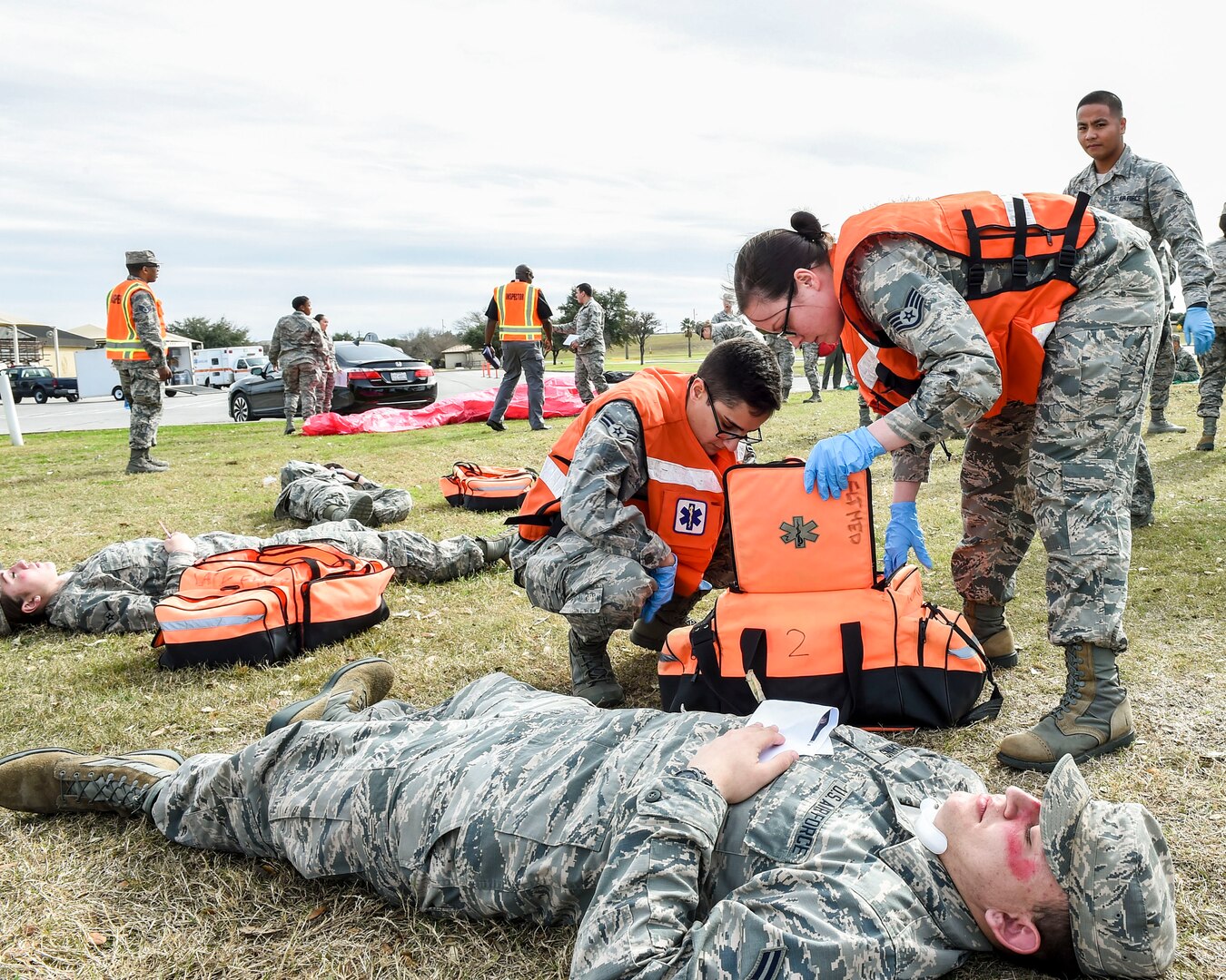 Airmen assess and prepare to triage a simulated patient prior to transport on an awaiting ambulance bus during an improved explosive device emergency response exercise Jan. 25, 2017, on Joint Base San Antonio, Texas-Lackland. The exercise tested the 59th Medical Wing’s clinical and field response teams’ readiness in advent of an on-base mass casualty incident. (U.S. Air Force photo/Staff Sgt. Michael Ellis)