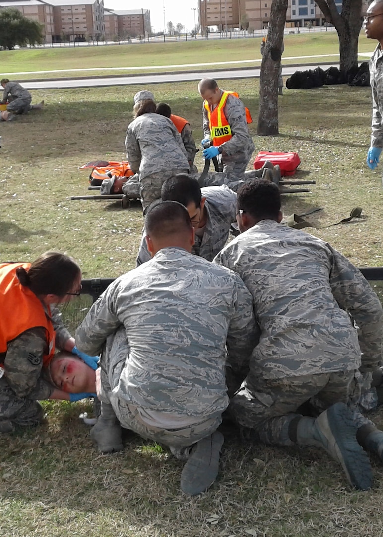 Airmen secure a simulated patient prior to transport on an awaiting ambulance bus during an improved explosive device emergency response exercise Jan. 25, 2017, on Joint Base San Antonio, Texas-Lackland. The exercise tested the 59th Medical Wing’s clinical and field response teams’ readiness in advent of an on-base mass casualty incident. (courtesy photo)