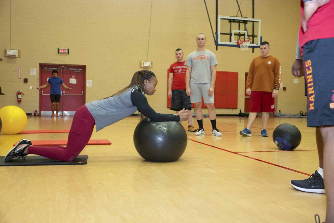 Tihynna Debose, a high Intensity Tactical Training assistant coordinator and fitness instructor with Semper Fit, demonstrates the proper execution of a core exercise using a stability ball during a circuit workout at Hopkins Hall Gym aboard Camp Allen in Norfolk, VA., on Jan. 24, 2017. 
