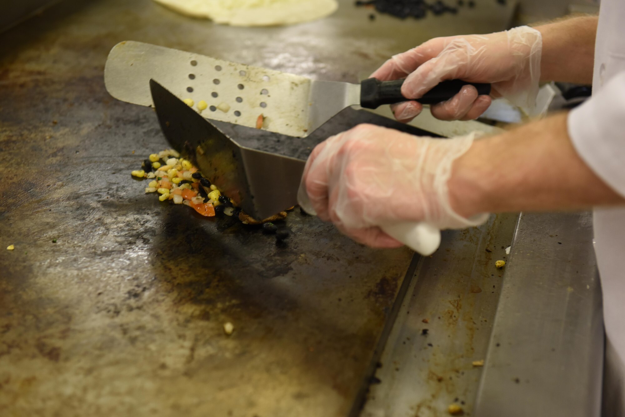 Airman 1st Class Kyle Harris, 2nd Force Support Squadron services Airman, prepares a quesadilla at the newly re-opened Red River Dining Facility at Barksdale Air Force Base, La., Feb. 2, 2017. The dining facility offers a large variety of food, giving airmen healthy and tasteful options for their meals. (U.S. Air Force photo/Senior Airman Luke Hill)