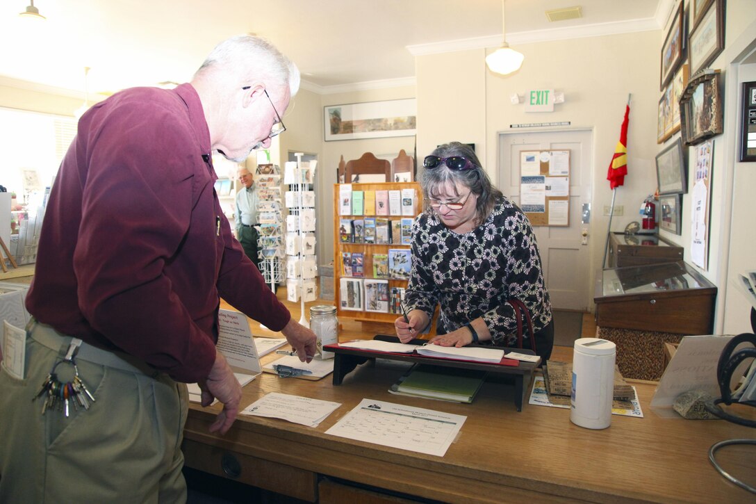 Vicki Mullen, wife of Brig. Gen. William F. Mullen III, Combat Center Commanding General, signs the guest book at the Old Schoolhouse Museum in Twentynine Palms, Calif., Jan. 31, 2017. With her is Twentynine Palms Historical Society President Les Snodgrass. The Mullens toured the facility with Sgt. Maj. Michael J. Hendges, Combat Center Sergeant Major; Cpl. Ben Mills, driver; Jim Ricker, Combat Center Assistant Chief of Staff for Government and External Affairs; and Kristina Becker, Combat Center External Affairs Director. (Official Marine Corps photo by Kelly O'Sullivan/Released)