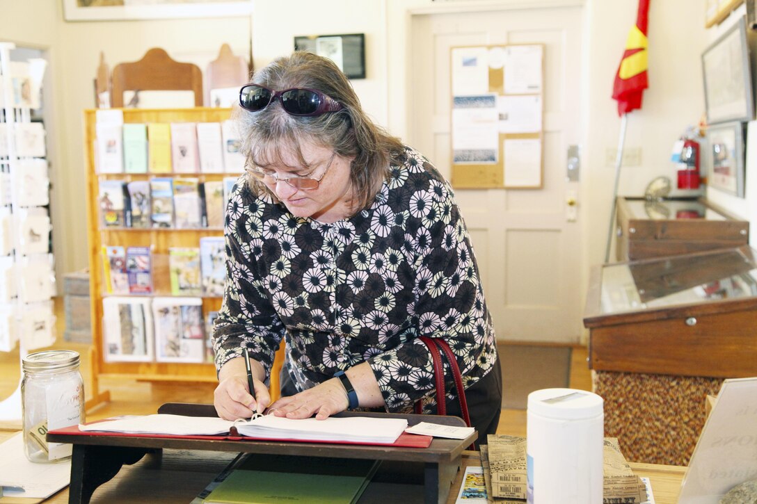 Vicki Mullen, wife of Brig. Gen. William F. Mullen III, Combat Center Commanding General, signs the guest book at the Old Schoolhouse Museum in Twentynine Palms, Calif., Jan. 31, 2017. The Mullens toured the facility with Sgt. Maj. Michael J. Hendges, Combat Center Sergeant Major; Cpl. Ben Mills, driver; Jim Ricker, Combat Center Assistant Chief of Staff for Government and External Affairs; and Kristina Becker, Combat Center External Affairs Director. (Official Marine Corps photo by Kelly O'Sullivan/Released)
