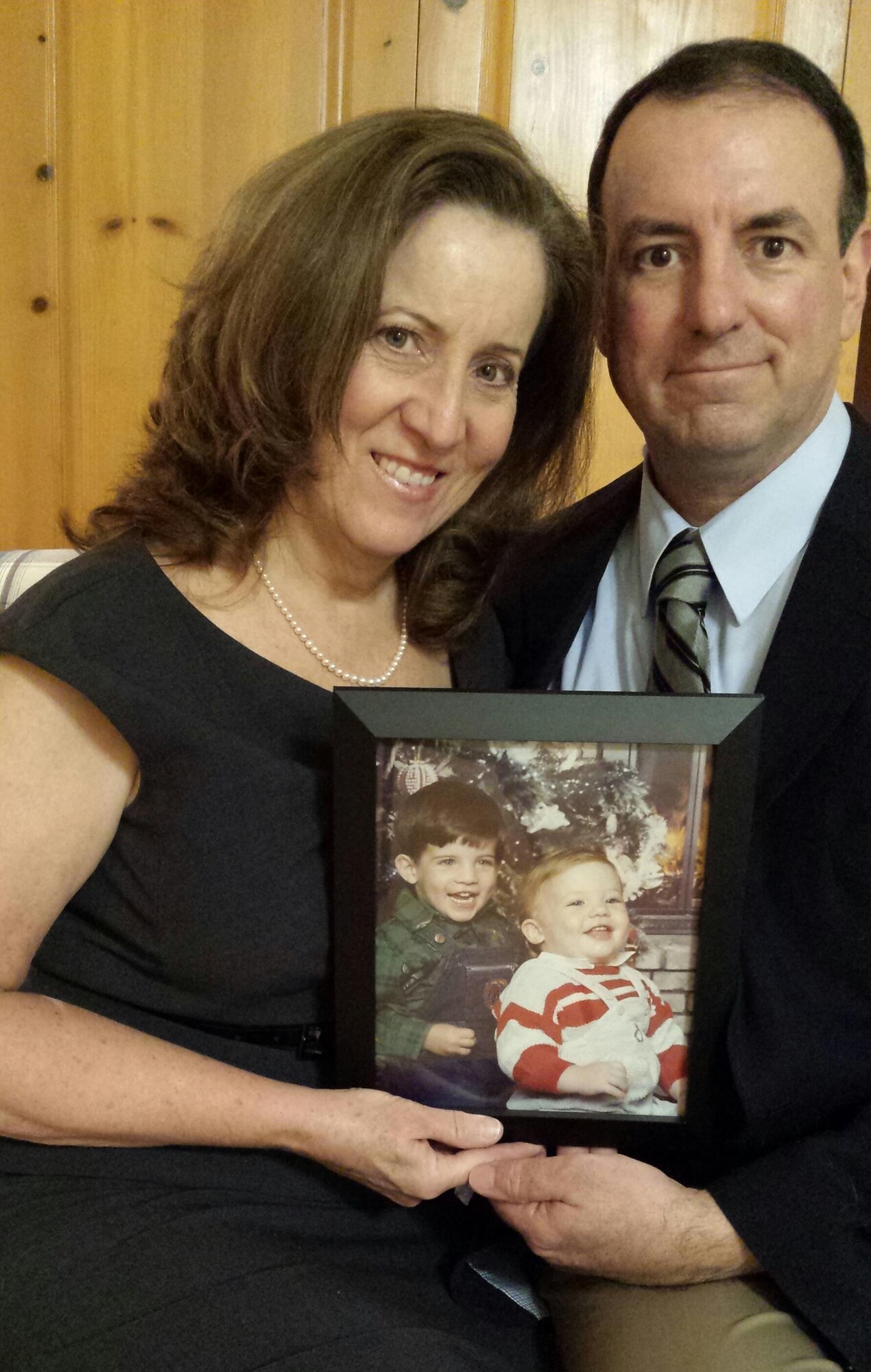 Roxann Burns and retired Chief Master Sgt. Bryan Burns, 60th Operations Support Squadron, pose for a photo in their home Feb. 7, 2017, while holding a photograph of Roxann and the couple’s first born son, Matthew Burns shortly after he was born in July 1986. Bryan traveled from then McChord Air Force Base, Wash., to Travis Air Force Base, Calif., in less than two hours to be there for Matthew’s birth. (Courtesy Photo)