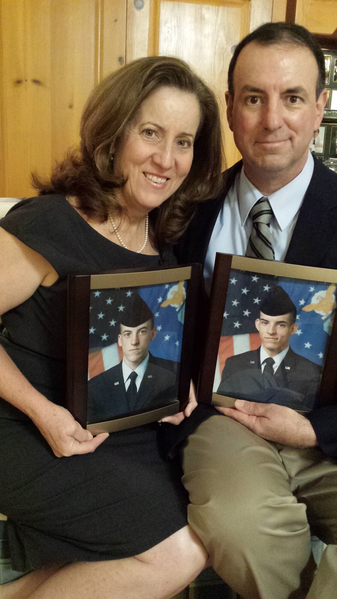 Roxann Burns and retired Chief Master Sgt. Bryan Burns, 60th Operations Support Squadron, pose for a photo in their home Feb. 7, 2017, while holding a photograph of their two children, Matthew and Joshua Burns. Matthew joined the Air Force and is currently a staff sergeant assigned to the 79th Air Refueling Squadron at Travis Air Force Base, Calif. Joshua also joined the Air Force and served nearly nine years as a KC-10 Extender boom operator. (Courtesy Photo)