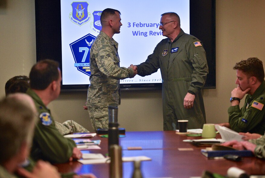 Col. Jonathan Philebaum, commander, 932nd Airlift Wing, presents Senior Airman Jay Brody, 12th Operational Weather Flight,  and wing coin for his Airman Spotlight presentation Feb. 3, 2017, Scott Air Force Base, Illinois.  Brody spoke about his reason for joining the Air Force Reserve Command and future goals with the Air Force. (U.S. Air Force photo by Christopher Parr)