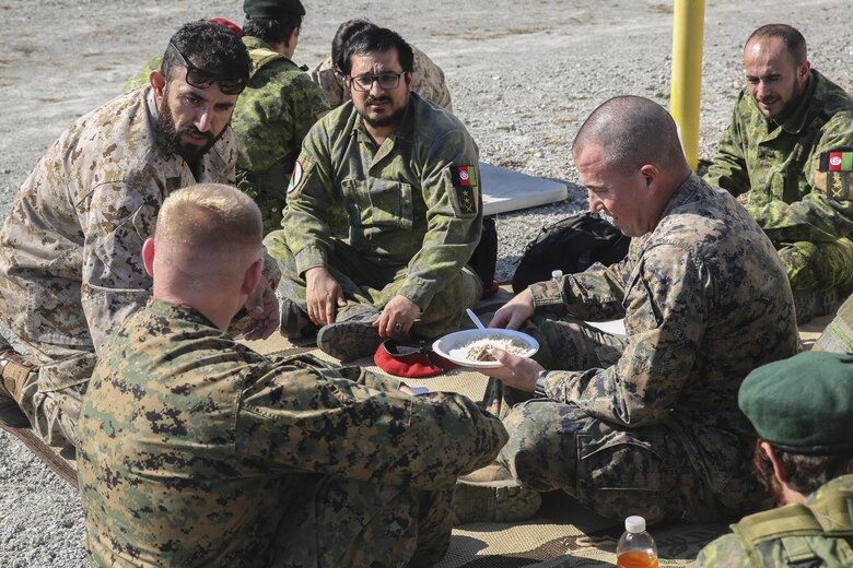 Marines with Task Force Southwest eat a meal with Afghani role players during a rapport-building exercise at Camp Lejeune, N.C., Feb. 2, 2016. Approximately 30 Marines with the unit worked to enhance their communication skills in preparation for an upcoming deployment to Helmand Province, Afghanistan. The Marines will train, advise and assist the Afghan National Army 215th Corps. (U.S. Marine Corps photo by Sgt. Lucas Hopkins)