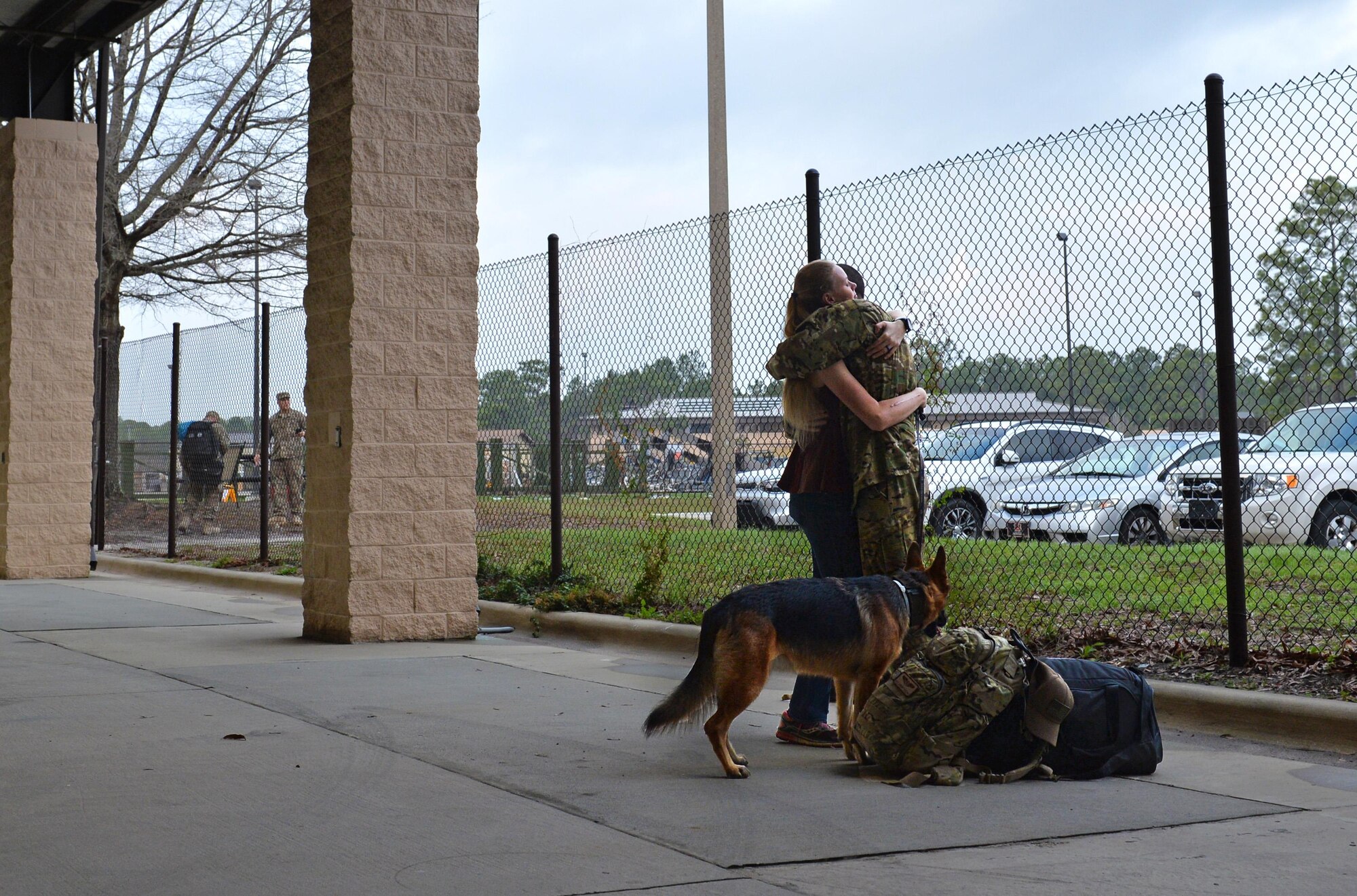 Staff Sgt. Jeremy Wolski, a loadmaster with the 15th Special Operations Squadron, is greeted by his wife and dog during an Operation Homecoming at Hurlburt Field, Fla., Feb. 7, 2017. Close to 190 Air Commandos were greeted by friends and family upon returning home from deployed locations. (U.S. Air Force photo by Senior Airman Andrea Posey)