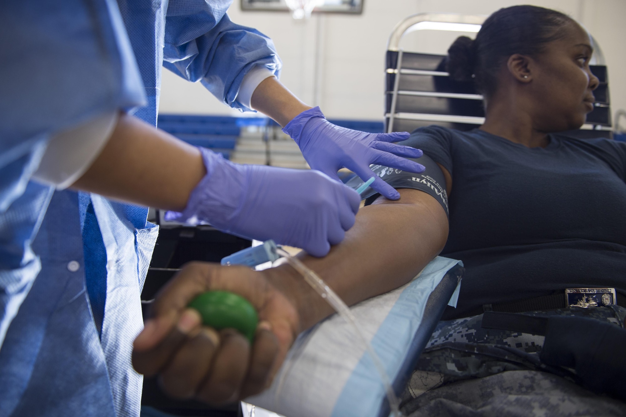 Petty Officer 1st Class Ebony Turner, Naval Communications Security Material Systems information systems technician, squeezes a ball and looks away before the needle goes into her arm during the Armed Services Blood Bank Center’s blood donation on Joint Base Andrews, Md., Feb. 6, 2017. The ASBBC is run by U.S. Navy personnel stationed out of Walter Reed National Medical Center. (U.S. Air Force photo by Senior Airman Philip Bryant)
