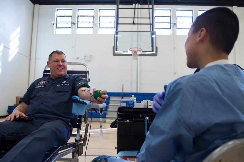Master Sgt. Dan Hjelstrom, Presidential Airlift Group crew chief, speaks to his technician while giving blood during the Armed Services Blood Bank Center’s blood donation on Joint Base Andrews, Md., Feb. 6, 2017. Blood received by the ASBBC is shipped to military treatment facilities across the globe and used overseas at forward deployed locations. (U.S. Air Force photo by Senior Airman Philip Bryant)