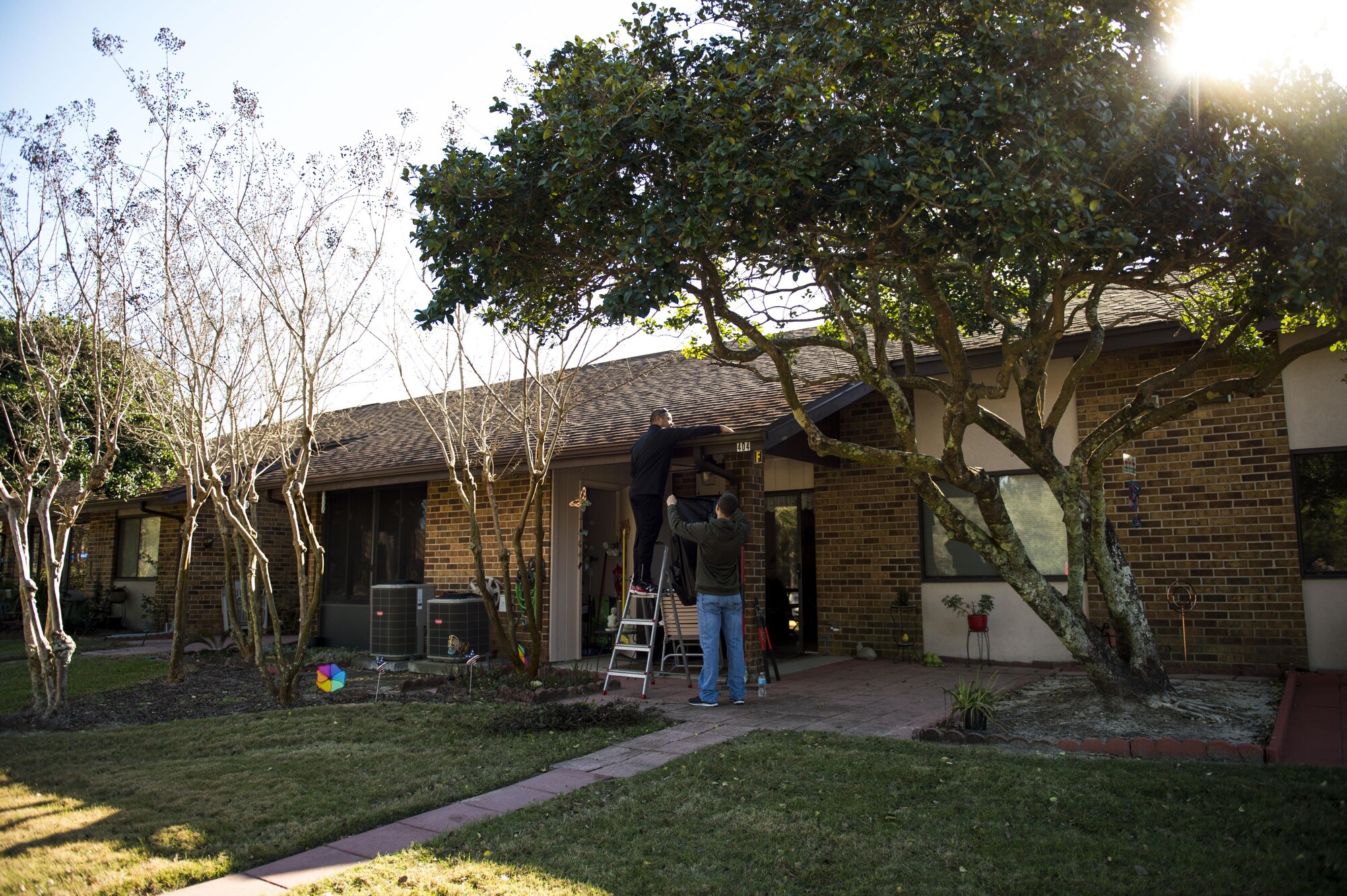 Lt. Col. Derrick Barton, the commander of the 4th Special Operations Squadron, removes leaves from the gutters of a resident’s roof at the Bob Hope Village in Shalimar, Fla., Feb. 2, 2017. Air Commandos with the 4th SOS assist residents of the Bob Hope Village, at least once a month, with minor maintenance request and yard work. (U.S. Air Force photo Senior Airman Krystal M. Garrett)